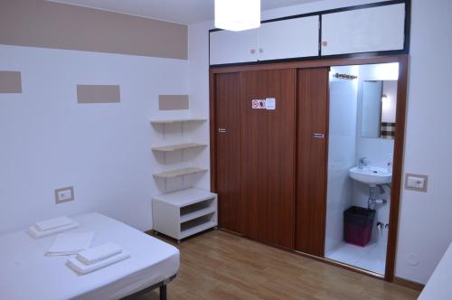 baño con lavabo y puerta de madera en ArArAt Hostel, en Santiago de Compostela