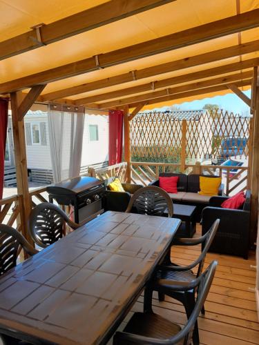 a patio with tables and chairs on a deck at Grand mobilhome spacieux 8 places frejus/straphael in Fréjus