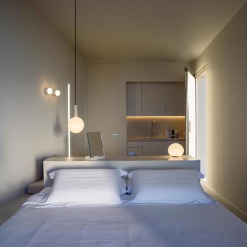 a bedroom with a large bed with two white pillows at Santopaz Suites in Oia