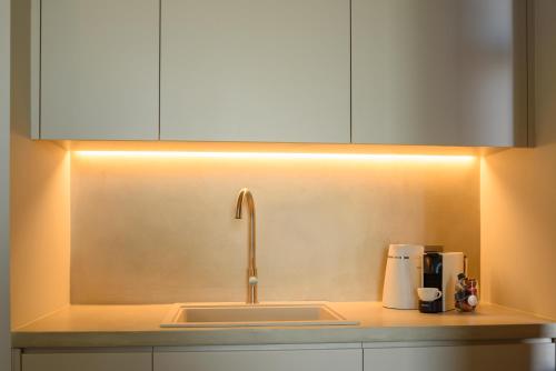 a kitchen with a sink with a light above it at Santopaz Suites in Oia