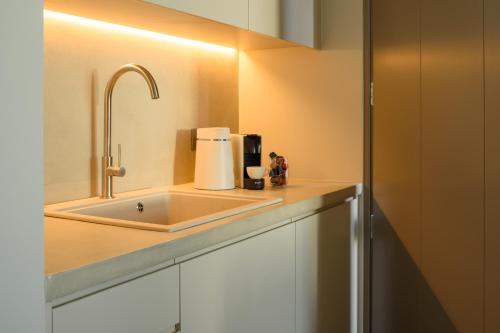 a kitchen counter with a sink and a coffee maker at Santopaz Suites in Oia