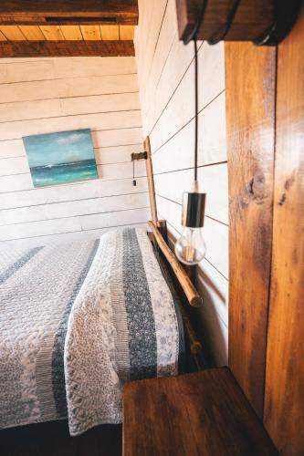 a bedroom with a bed in a wooden wall at Morros del Pacífico in Pichilemu