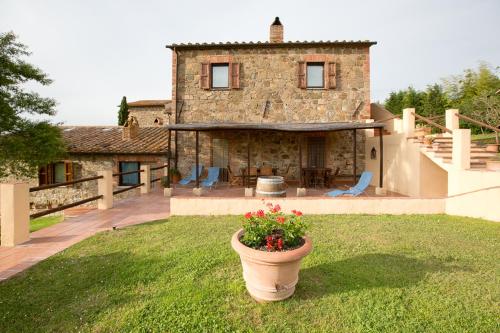 a house with a yard with a pot of flowers at Podere Il Tigliolo in Castiglione dʼOrcia