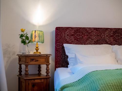a bedroom with a bed and a table with a lamp at Katzerhaus Ebensee in Ebensee