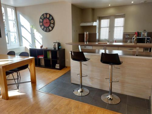 a kitchen with two bar stools and a counter at Le Bullière 60m2 plein centre! in Rodez