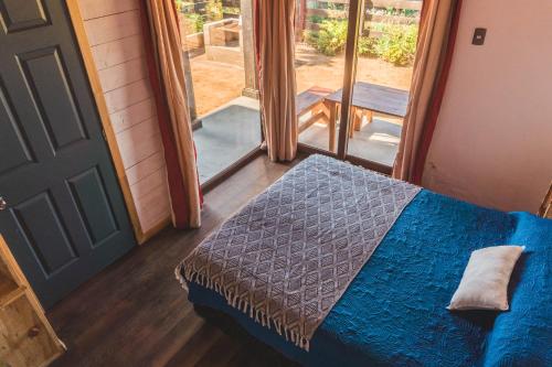 a bedroom with a bed and a door to a porch at Morros del Pacífico in Pichilemu