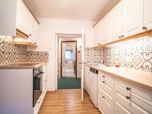 a kitchen with white cabinets and a hallway at Katzerhaus Ebensee in Ebensee
