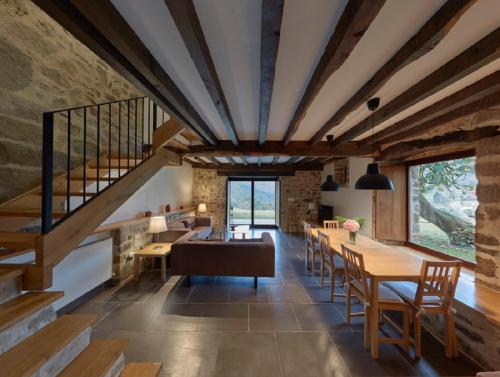 a living room with a staircase and tables and chairs at Casa de Aldea Casa de Rubio in Linares