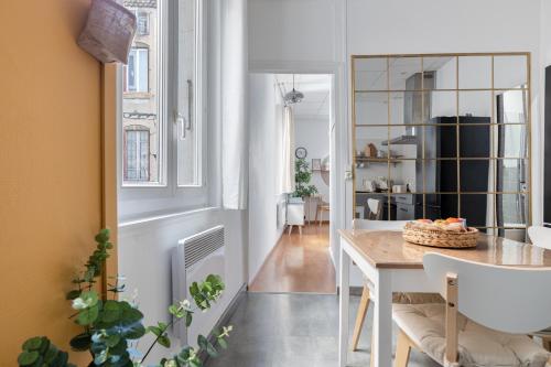 eine Küche und ein Esszimmer mit einem Tisch und Stühlen in der Unterkunft Appartement 1er étage piéton Place de la Pierre in Valence