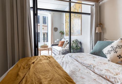 um quarto com uma cama e uma grande janela em Appartement 1er étage piéton Place de la Pierre em Valence