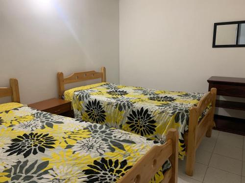 2 camas en una habitación de color amarillo y negro en Casa amplia cerca del cc Titan Plaza, en Bogotá