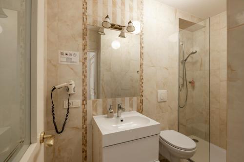 y baño con aseo, lavabo y ducha. en Guoda Apartments en Vilna