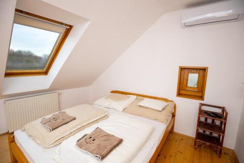 1 dormitorio con 1 cama con sábanas blancas y ventana en NOBLE'S Panzió és Étterem, en Nemesnép