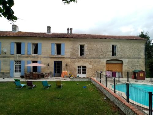 une vieille maison avec une piscine en face de celle-ci dans l'établissement les Ormes de Belluire, à Belluire