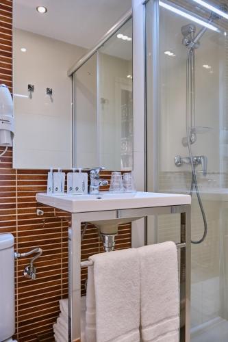 a bathroom with a white sink and a shower at Hostal Suso in Santiago de Compostela