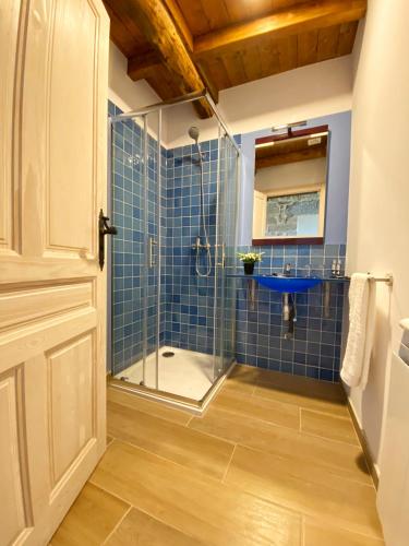 a bathroom with a shower with blue tiles at Casa do Veiga in Chantada