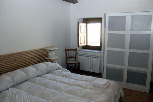 a bedroom with a bed and a window and a chair at Kame house in Castelbuono