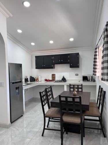 a kitchen with black cabinets and a table and chairs at Cabañas el Pino 2 in Creel