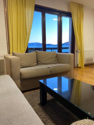 a living room with a couch and a glass table at Zlatibor Tornik View in Zlatibor