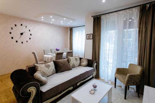 ein Wohnzimmer mit einem Sofa und einem Tisch in der Unterkunft Apartman Kristina 4* in Subotica