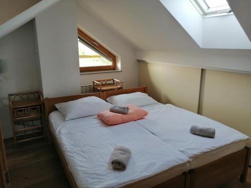a bedroom with a bed with two pillows and a window at Guest House Eco Vila Mila in Rogaška Slatina