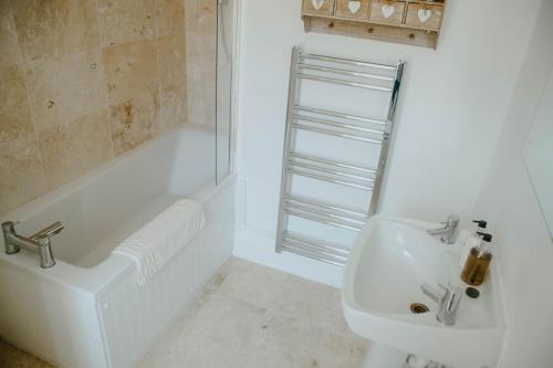 een badkamer met een bad, een wastafel en een douche bij Toghill House Farm in Wick