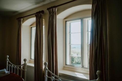 a bedroom with a bed and a window with curtains at Toghill House Farm in Wick