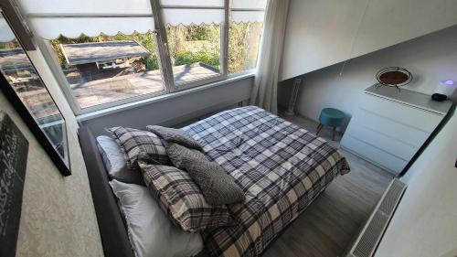 a small bedroom with a bed and a window at Lake House 74, luxury accommodation ir Sauna in Warmond