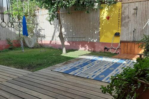 a yard with a wooden deck with a mat on the ground at Cosy Family Home & Garden in Eilat in Eilat