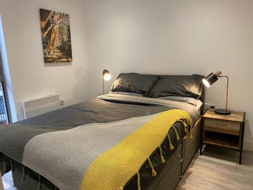 een bed in een slaapkamer met een lamp op een tafel bij Snuggle Flat in Sheffield in Sheffield