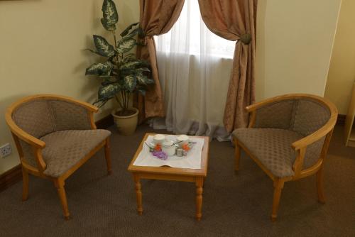 a living room with two chairs and a coffee table at The Elegant Lodge Menlo Park in Pretoria