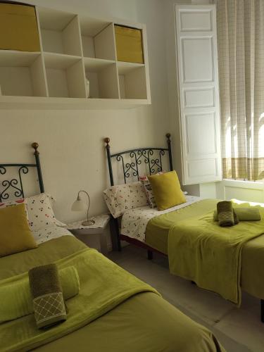 a bedroom with two beds with green sheets at Principe A in Granada