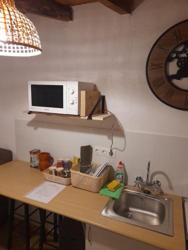 - un comptoir de cuisine avec évier et four micro-ondes dans l'établissement Habitación rústica independiente con todas las comodidades y sofacama, à Tordesillas