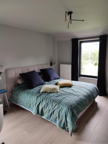 a bedroom with a large bed with two pillows on it at Housedurbuy in Durbuy