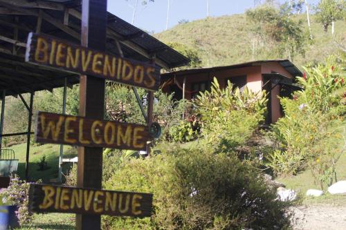 a pole with street signs in front of a house at Cabañas Colibrí Tayutic in Turrialba