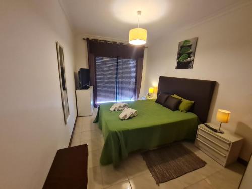 クアルテイラにあるQuarteira T1 - Oceanidesのベッドルーム(緑のベッド1台、窓付)