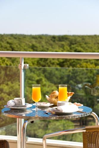 a table with food and two glasses of orange juice at Monte Gordo Hotel Apartamentos & Spa in Monte Gordo
