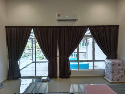 una gran ventana con cortinas en una habitación en D'Corner Homestay Kluang Perdana, en Keluang