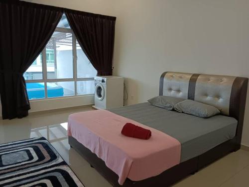 - une chambre avec un lit doté d'une couverture rose et d'une fenêtre dans l'établissement D'Corner Homestay Kluang Perdana, à Keluang