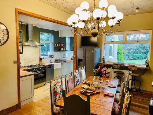 una cucina e una sala da pranzo con tavolo e lampadario pendente di Ladies Lodge Inverness a Inverness