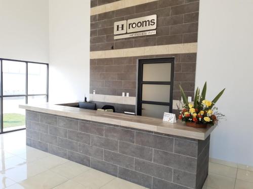 a lobby with a reception counter with flowers on it at H Rooms Hoteles Inn in La Piedad Cavadas