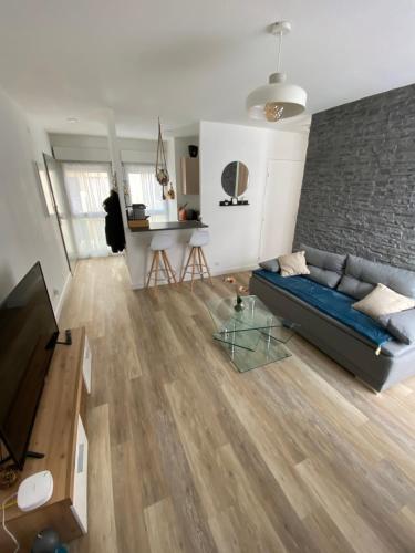 - un salon avec un canapé bleu et un mur en briques dans l'établissement Appartement au centre historique de Nîmes, à Nîmes