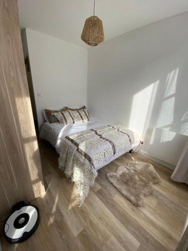 - une chambre blanche avec un lit doté d'une couette et d'un tapis dans l'établissement Appartement au centre historique de Nîmes, à Nîmes