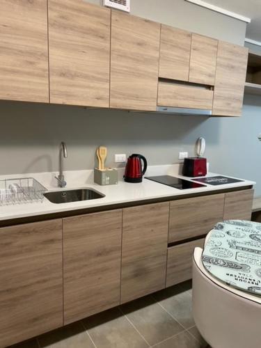 a kitchen with a sink and wooden cabinets at Apart Center Temuco in Temuco