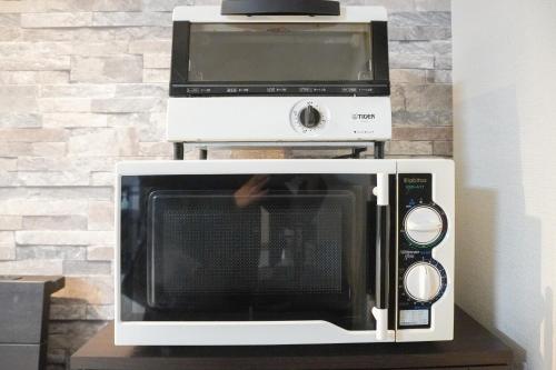 a microwave and a toaster oven on a table at Tiz 海岸通り in Sumoto