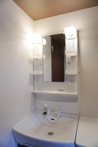 a bathroom with a sink and a mirror at Tiz 海岸通り in Sumoto