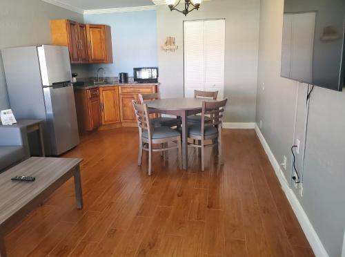 a kitchen with a table and chairs and a refrigerator at Vero Beach Inn & Suites Vero Beach I-95 in Vero Beach