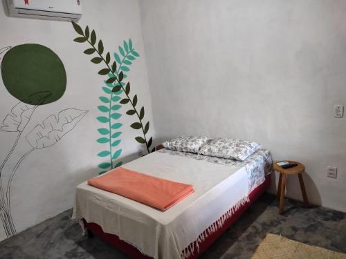 a small bedroom with a bed with an orange blanket at Recanto da Alice in Trancoso