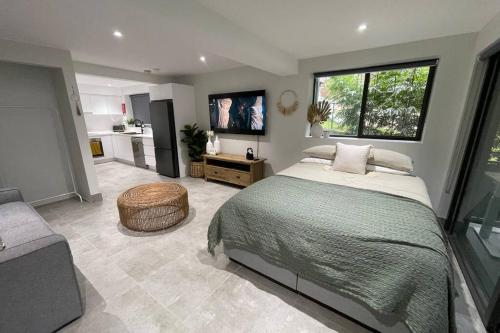 a bedroom with a large bed and a kitchen at Quiet private getaway, private gym walk 2 beach in Terrigal
