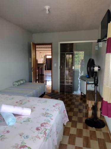 a hotel room with two beds and a fan at Suítes Ponta do Sol (Trator) in Capitólio